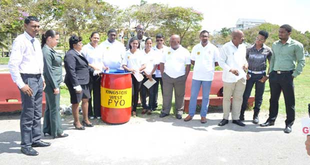 Some members of the Kingston West Progressive Youth Organisation (PYO)  with Minister Norman Whittaker and Town Clerk (ag) Carol Sooba during yesterday’s simple but significant handing over of the drums  for garbage.