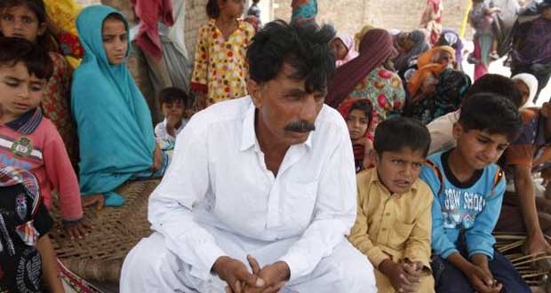 Muhammed Iqbal, 45, husband of the late Farzana Iqbal, sits with his family members at his residence in a village in Moza Sial, west of Lahore May 30, 2014. Credit: REUTERS/Mohsin Raza