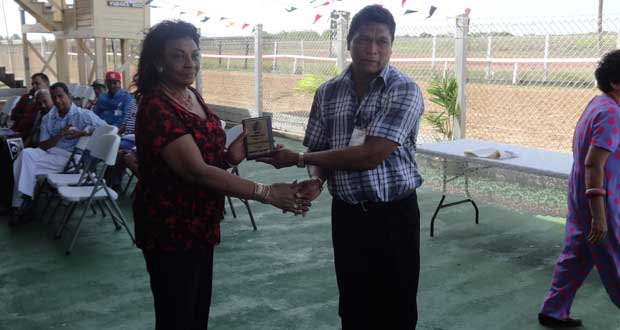 Caretaker Elroy Johnson accepts his award from Justice Claudette Singh