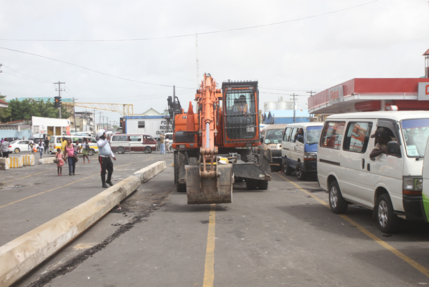 Putting in place the concrete columns to prevent buses from breaching their lanes, as drivers look on