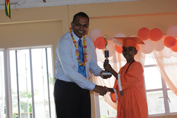 Dr. Anthony presenting a trophy to the best graduating student, Amit Dass