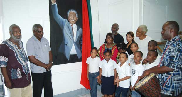Guyanese Sculptor, Ivor Thom (left), Minister of Public Works, Robeson Benn (second from left) and in the back row Registrar of University of Guyana, Vincent Alexander (left) and Artist, Tammy Walker along with students of the summer programme unveiling the portrait of Nelson Mandela at the Museum of African Heritage (Cullen Bess-Nelson photo)