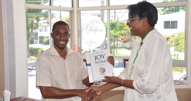 President of the Language Institute, Ms. Cecily Bernard makes extends appreciation with token to photographer at the Guyana Chronicle, Mr. Delano Williams
