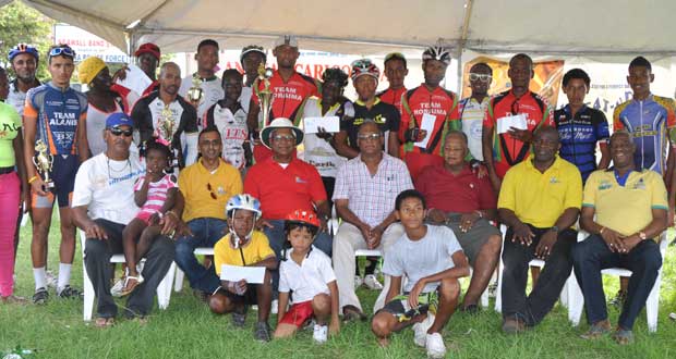 Prize winners of the various categories of the NAMILCO-sponsored Annual CARICOM 13-race cycle programme strike a pose with event organisers and sponsors yesterday, at the Seawall Bandstand.