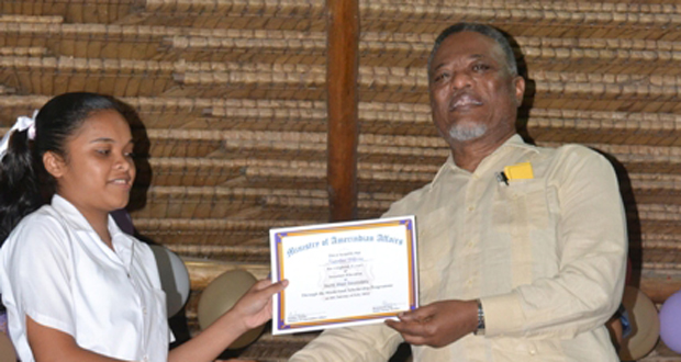 A proud graduand receives her certificate of achievement from Prime Minister Samuel Hinds