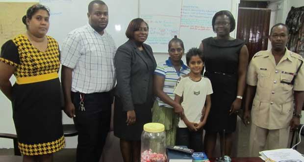 Commander Hicken (right) and Deputy Superintendent Scipio (second left) with one of the beneficiaries and his mother, and some of the  lawyers