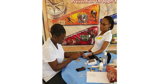 GDF Sergeant Geralda Jeffery as she attends to a visitor at the recent medical outreach partnered by UG students and the GDF