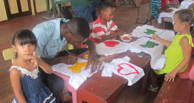 A junior police rank takes time off from policing to assist a young child with her fabric painting