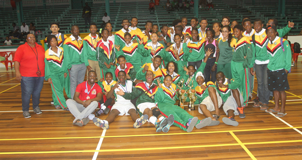 Athletes and officials from the Guyana team celebrate last Sunday night at the Cliff Anderson Sports Hall. (Sonell Nelson photo)