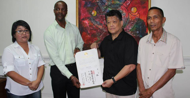Permanent Secretary, Alfred King receives Minister Anthony's certificate recognising him as a 6th Dan Black Belt from Grand Master Sensai Frank Woon-A-Tai of the Guyana Karate College