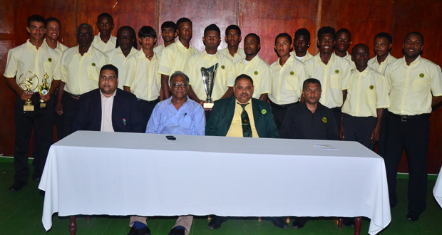 Proud champions Guyana with skipper Brian Sattaur holding the Regional Under-19 trophy. Seated at front row  form left are GCB treasurer Anand Kalladeen,  Director of Sport Neil Kumar, GCB president Drubahadur and Secretary Anand Sanasie. (Photos by Adrian Narine).