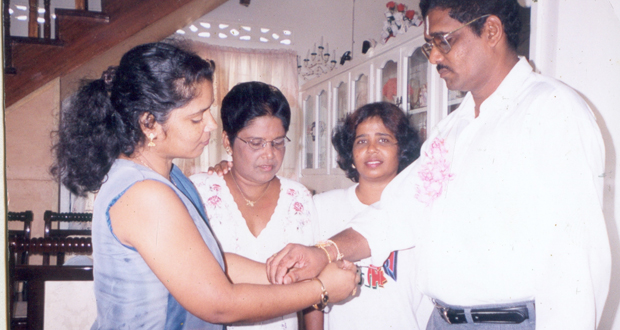 A sister ties a Rakhi on the wrists of her brother, while two other sisters                         awaits their turn.