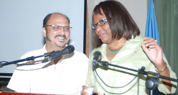 Health Minister Dr Bheri Ramsaran and PAHO Director Dr Carissa Etienne share a light moment at the podium during Thursday’s cocktail reception at the Royal Restaurant at Princess Hotel