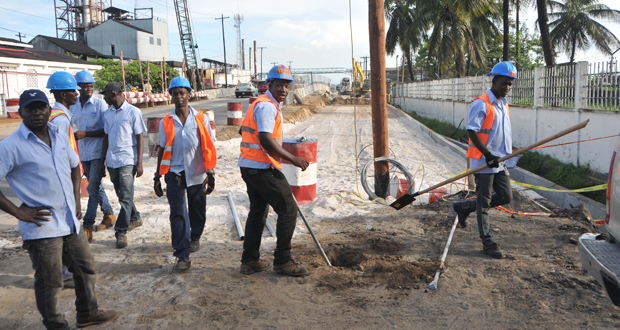 GT&T staff preparing to replace the fallen utility pole at the centre of  the  new carriageway (Photo courtesy of BK International)