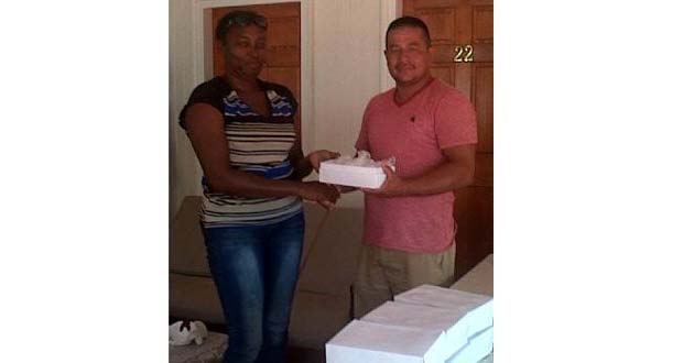 Secretary of Pomeroon Sports Committee, Verna D’Aguiar, hands over a box of balls to captain of Eagles Sports Club, Kenneth De Agrella.