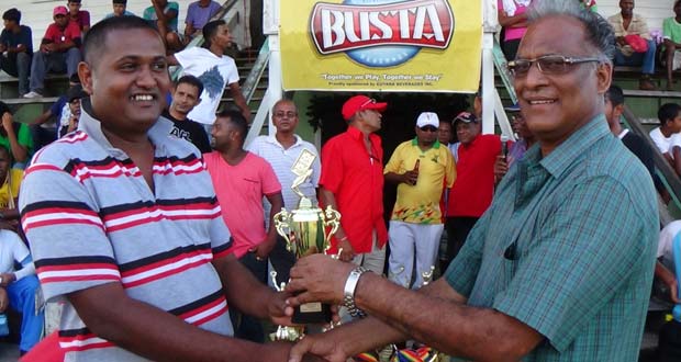 Director of Sport Neil Kumar (right) hands over the trophy, that was up for grabs for the dominoes competition, to the captain of the victorious Enterprise Shop team.