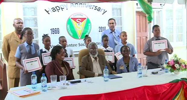 Chairman of the Board of the National Insurance Scheme, Dr. Roger Luncheon, with senior officials from the scheme and students who have been awarded bursaries