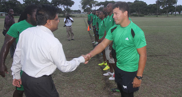 Finance Minister Dr Ashni Singh greets National 7s Rugby captain Ryan Gonsalves yesterday at the National Park Rugby field. (Sonell Nelson photo)