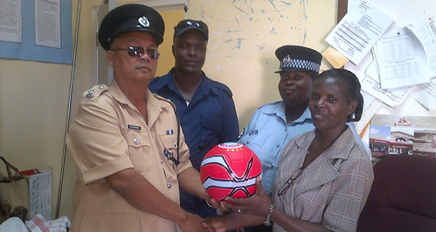 Officer in Charge of the Bartica Police Station, ASP R. Banwarie, and Woman Police Sgt Felix are seen with Police Constable Aaron as they present sports gear to Head Mistress of the Three Miles Secondary School.
