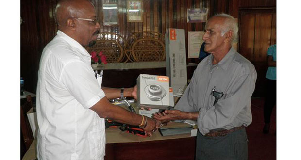 Regional Development and Local Government Minister, Mr. Norman Whittaker handing over a brushcutter to Chairman of the Charity-Urasara NDC, Mr. Macbool Basir at Anna Regina on Wednesday
