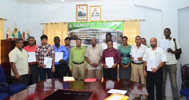 Local Government and Regional Development Minister, Norman Whittaker (centre) with contract awardees and other representatives from the Local Government Ministry