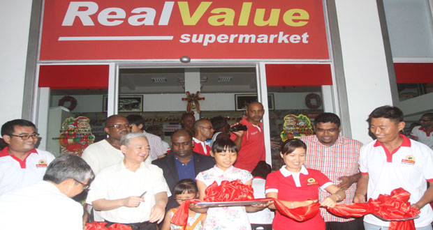 Chinese Ambassador, Mr Zhang Limin as he cut the ribbon signalling the official opening of Real Value Supermarket Saturday night flanked by the owner, Mr Jason Wang; PSC President, Mr Ramesh Persaud; Minister Irfaan Ali and others