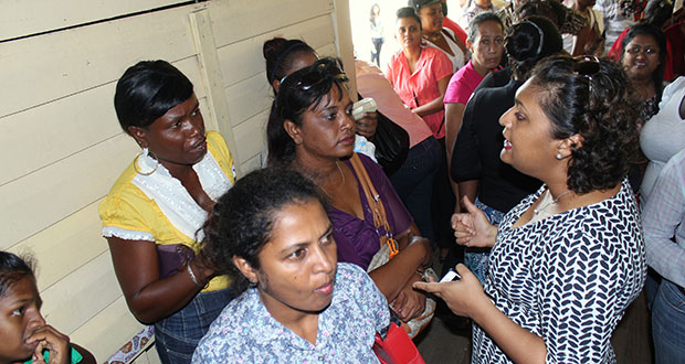Minister Manickchand takes time to explain to parents what they need to do as they wait to uplift their 'Because we Care' vouchers