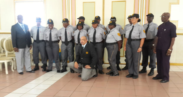Former policeman, Mr. Cortland Gordon (left); General Manager, Mr. Wayne Clarke (kneeling at centre); and former Deputy Commissioner of Police of Trinidad and Tobago, Mr. David Douglas (right) with the new batch of security officers following the graduation ceremony