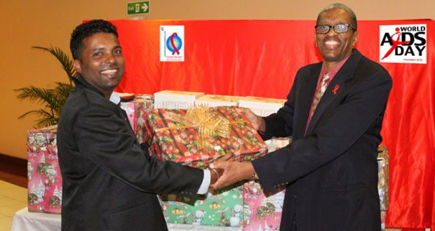 General, Dr. Douglas Slater, handing over one of several gifts to Mr. Amar Ramesar, Manager of the National AIDS Programme Food Bank.
