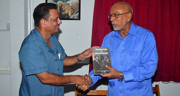 President Donald Ramotar receiving his copy of ‘Pragmatism or Opportunism’ from the author, Mr Hydar Ally at the launching Wednesday