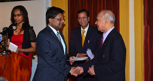 Minister of Finance Dr. Ashni Singh as he was presented with the first Signature Credit Card by Chairman of the Bank, Dr. Yesu Persaud as the bank’s Chief Executive Officer, Pravinchandra Dave, looks on.