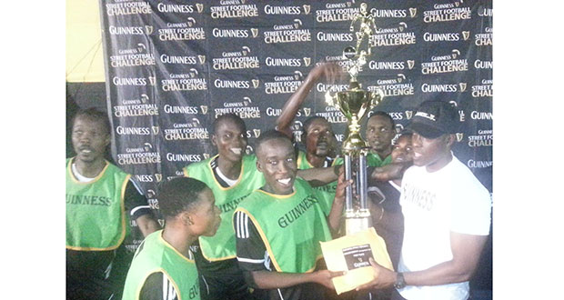 Yes, we are the champions! An ecstatic Joshua Browne, captain of the victorious North Ruimveldt team, smiles broadly as he collects the first place trophy and cash prize from Banks DIH’s Guinness Brand Manager Lee Baptiste, while his teammates share the moment gleefully.