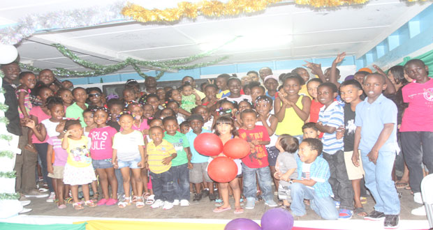 Police ranks pose with the children after the party (Photo By Sonell Nelson)