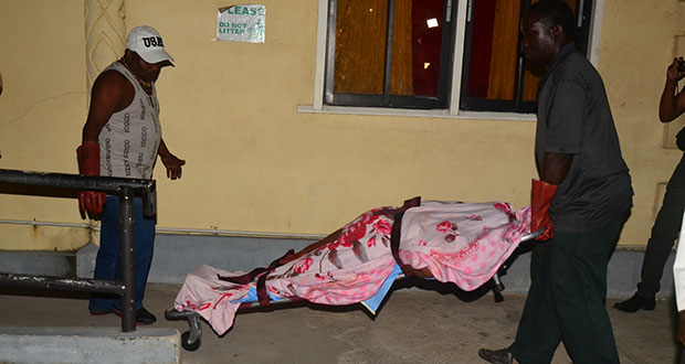 The body of the woman being removed from the hospital by undertakers on Tuesday night.