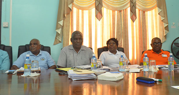 Public Works Minister, Robeson Benn along with some of the department heads paying keen attention to the reports