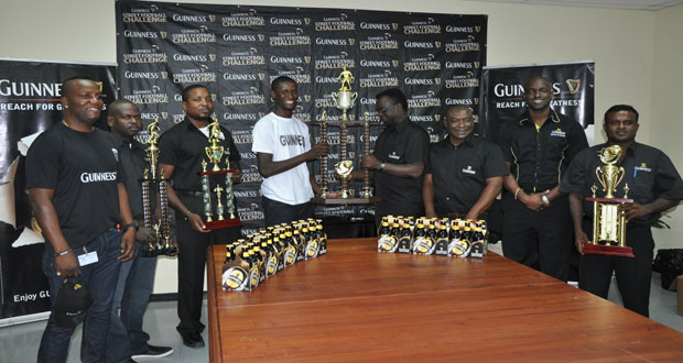 Guinness Street Football Challenge ‘West Side’ Edition coordinator Travis Bess receives the winners’ trophy from Guinness representative yesterday at the launching of the tournament.