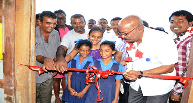 Minister of Local Government & Regional Development, Norman Whittaker along with beneficiaries and officials cutting the traditional ribbon to officially open the Friendship swine facility