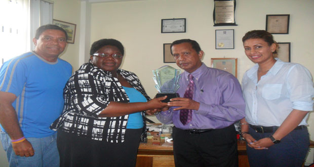 In photo Ms McCalman presents a plaque to Mr Panday Looking on approvingly are Mr John Goede, ITF Development Officer for the Caribbean and Ms Elizabeth Persaud, treasurer of the Guyana Lawn Tennis Association.