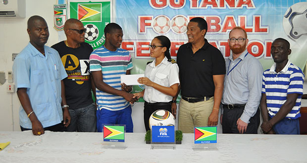 Tiffany Herbert hands over the ticket to Domini Garnett in the presence of, from right, Wayne Francois, Stuart May, Kashif Muhammad, James Herbert and Garnett’s father, Mark.