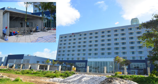 The almost complete Marriott Hotel, which is billed to be opened shortly. Inset is a close-up of work being done outside the building (Photos by Adrian Narine)