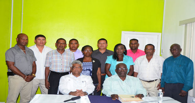 Standing are the ten Returning Officers who were sworn in yesterday in the company of GECOM Chairman Dr. Steve Surujbally (seated at left), and Chief Elections Officer (CEO) Keith Lowenfield.