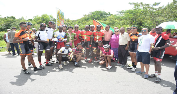 Minister of Sport Dr Frank Anthony (sixth right) strikes a pose with prize winners of the various categories and other well-wishers of the first stage of the Dr Cheddi Jagan Memorial three stage cycle road race yesterday. Also in this Samuel Maughn photo, is Director of Sport Neil Kumar (centre), while on Minister Anthony’s left are PPP’s parliamentarian Bibi Shadick, Hassan Mohamed and race sponsor Nazir Ahmad .