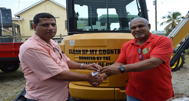 Collin Croal, Permanent Secretary, MLGRD, hands over one mini-excavator, one tractor and trailer, and 25 solid waste receptacles to the Regional Executive Officer, Peter Ramotar