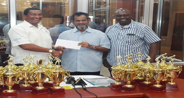 Directors of the K&S Organisation Kashif Muhammad (left) and Aubrey ‘Shanghai’ Major collect the $2M cheque from Mohamed’s Enterprise proprietor Nazar Mohamed.