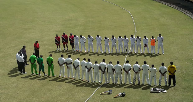 Players and officials from both sides along with the umpires observe a minute’s silence before the start of play yesterday for the late TTCB president Alloy Lequay who passed away Sunday morning.