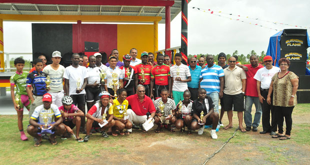 Prize winners of the various categories of the second stage of the 18th annual Dr. Cheddie Jagan Memorial three-stage cycle road race strike a pose with Director of Sport Neil Kumar (stooping centre), Minister of Sport Dr. Frank Anthony (partly hidden centre) and Minister of Health Dr. Beri Ramsarran (second right) after the presentation ceremony at Babu John, Port Mourant, yesterday.