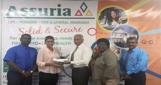 Assuria General Manager Yogindra Arjune (left), along with GTA president, Grace McCalman (2nd right) and vice-president Ramesh Seebarran (right), looks on as GTA secretary Elizabeth Persaud accepts the sponsorship cheque from Assuria Operations Manager Clyde Muntslag.