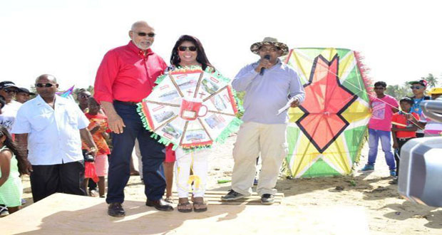 President Donald Ramotar, and Director of the Guyana Tourism Authority Indranauth Haralsingh presenting a woman with a prize for winning in the Tourism Ministry's  Kite flying competition