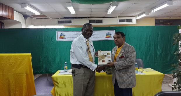 UG Vice-Chancellor Professor Jacob Opadeyi (left) accepting the books from Dr. Shamir Ally