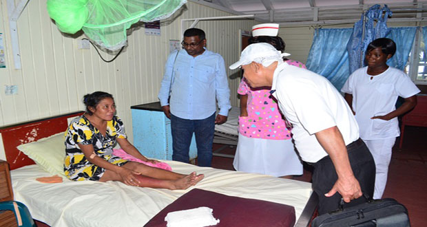 Minister of Public Health, Dr George Norton visiting with a patient at the Bartica Hospital